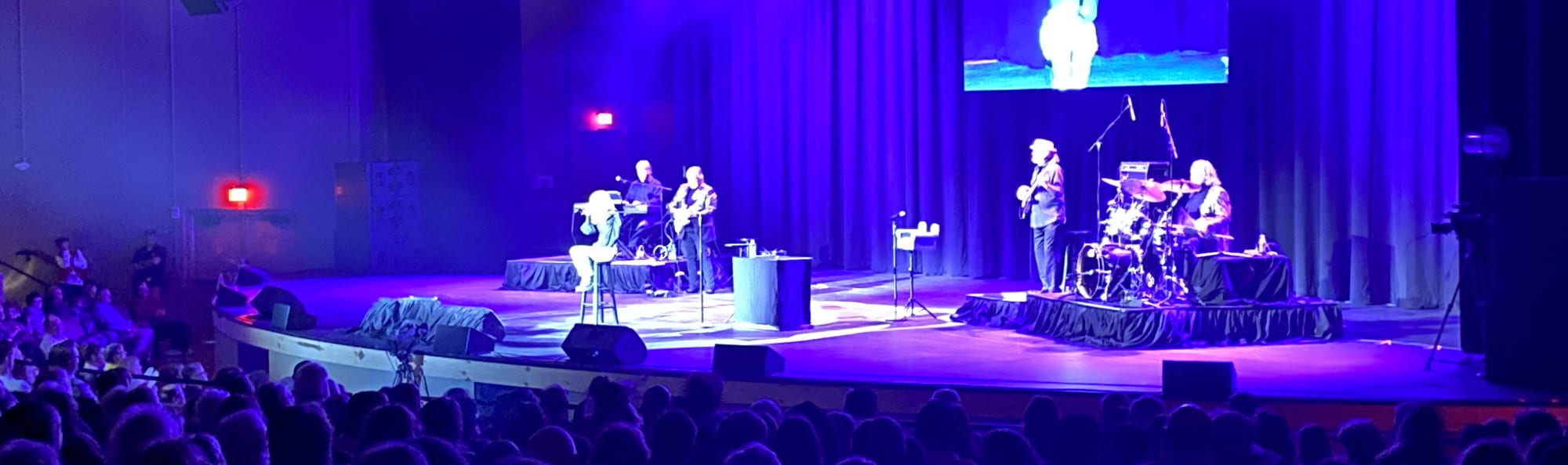 signer on stage in chair washed out by the lights Houston